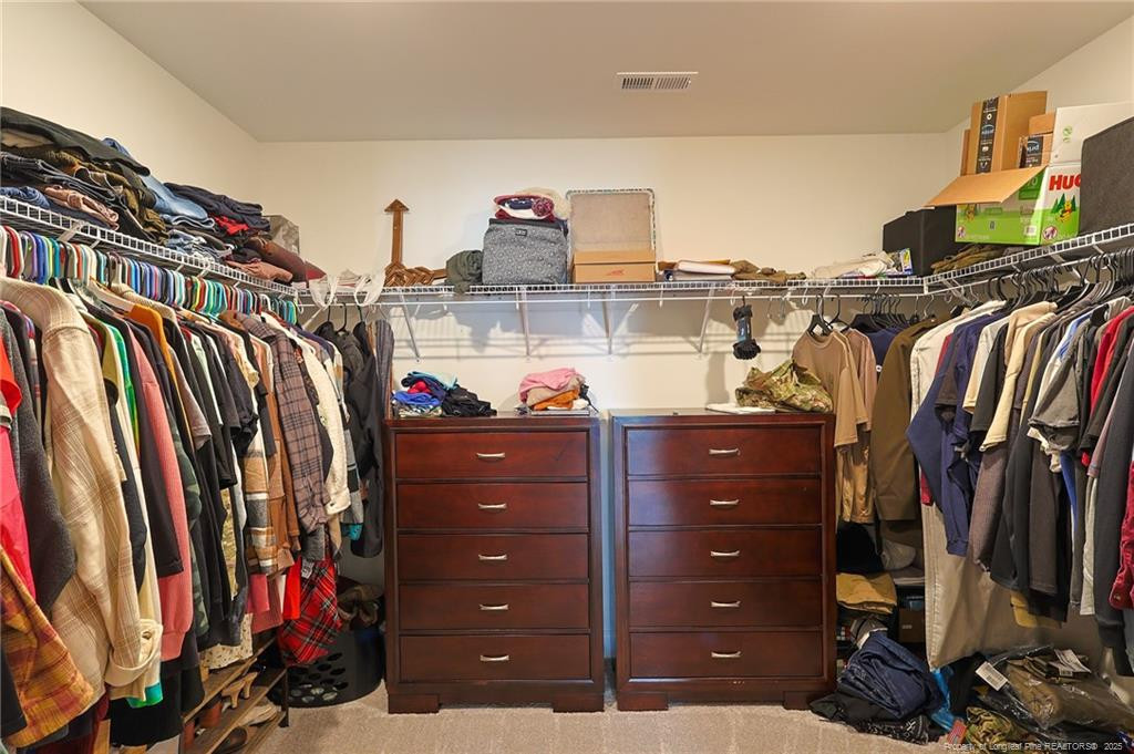 7810 Rufus Johnson Road St. Pauls, NC 28384 - Photo 9 of 24 a view of walk in closet with clothes and shoes