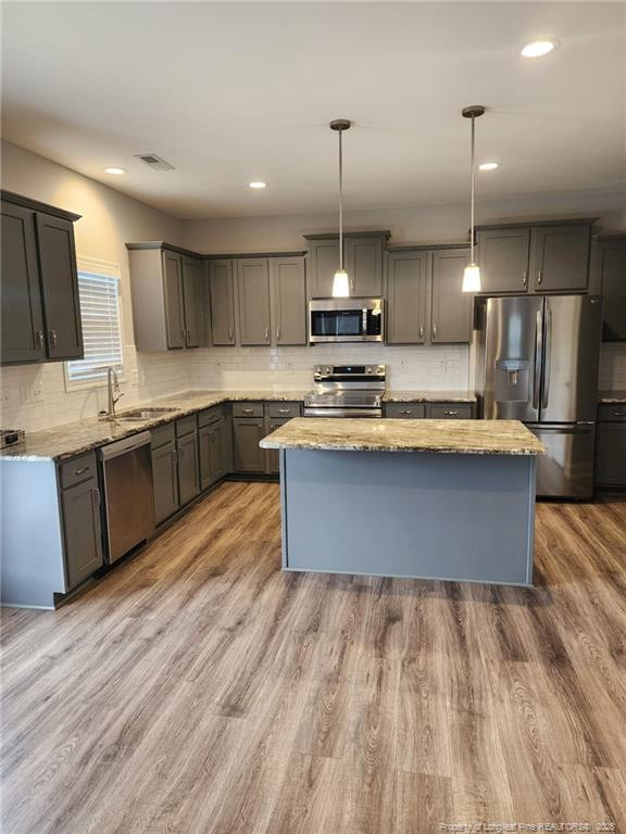 7810 Rufus Johnson Road St. Pauls, NC 28384 - Photo 9 of 27 a large kitchen with stainless steel appliances granite countertop a sink a stove and a wooden floors