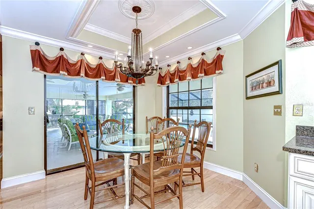 a view of a dining room with furniture a chandelier and wooden floor