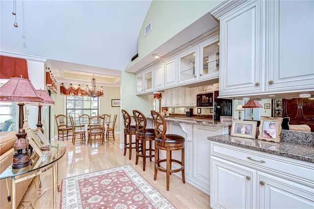 a kitchen with stainless steel appliances granite countertop a table chairs and a refrigerator