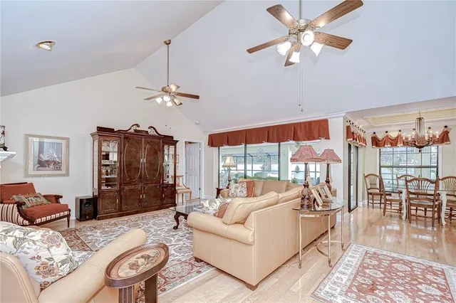a living room with furniture a dining table and a chandelier