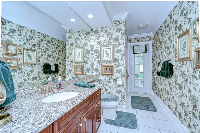 a bathroom with a granite countertop sink a toilet a mirror and shower