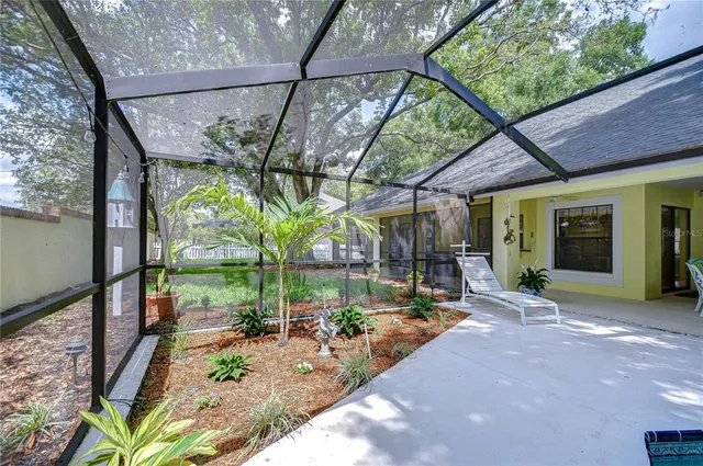 a view of a porch with couches and table and chairs under an umbrella