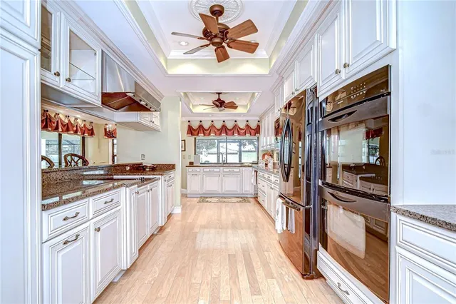 a large kitchen with stainless steel appliances granite countertop a large counter top a stove and a refrigerator