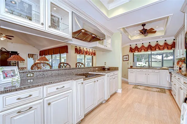 a large white kitchen with lots of counter space and wooden floor