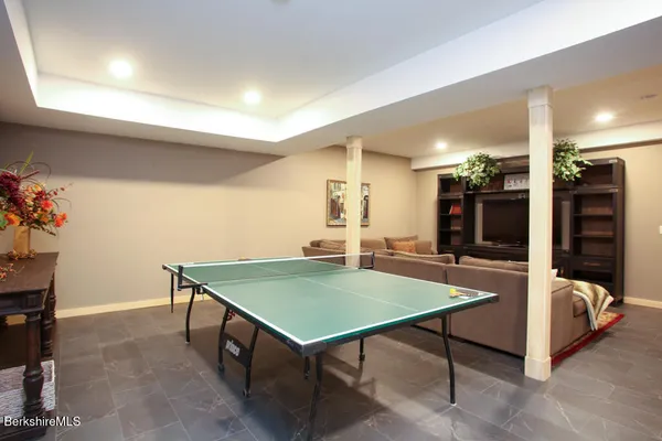 a room with furniture pool table and flat screen tv