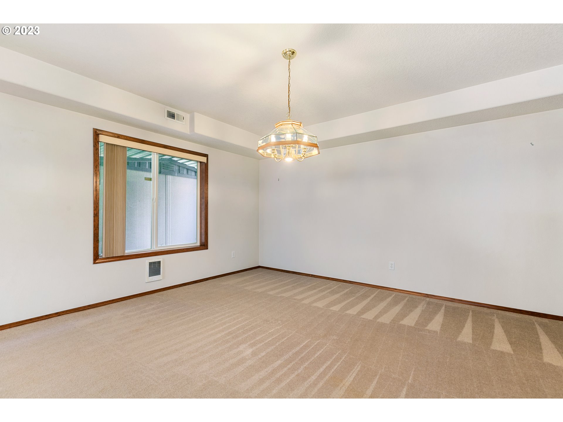 2217 Northeast 179th Street, Unit E10 Ridgefield, WA 98642 - Photo 17 of 23 a view of an empty room with window and chandelier fan