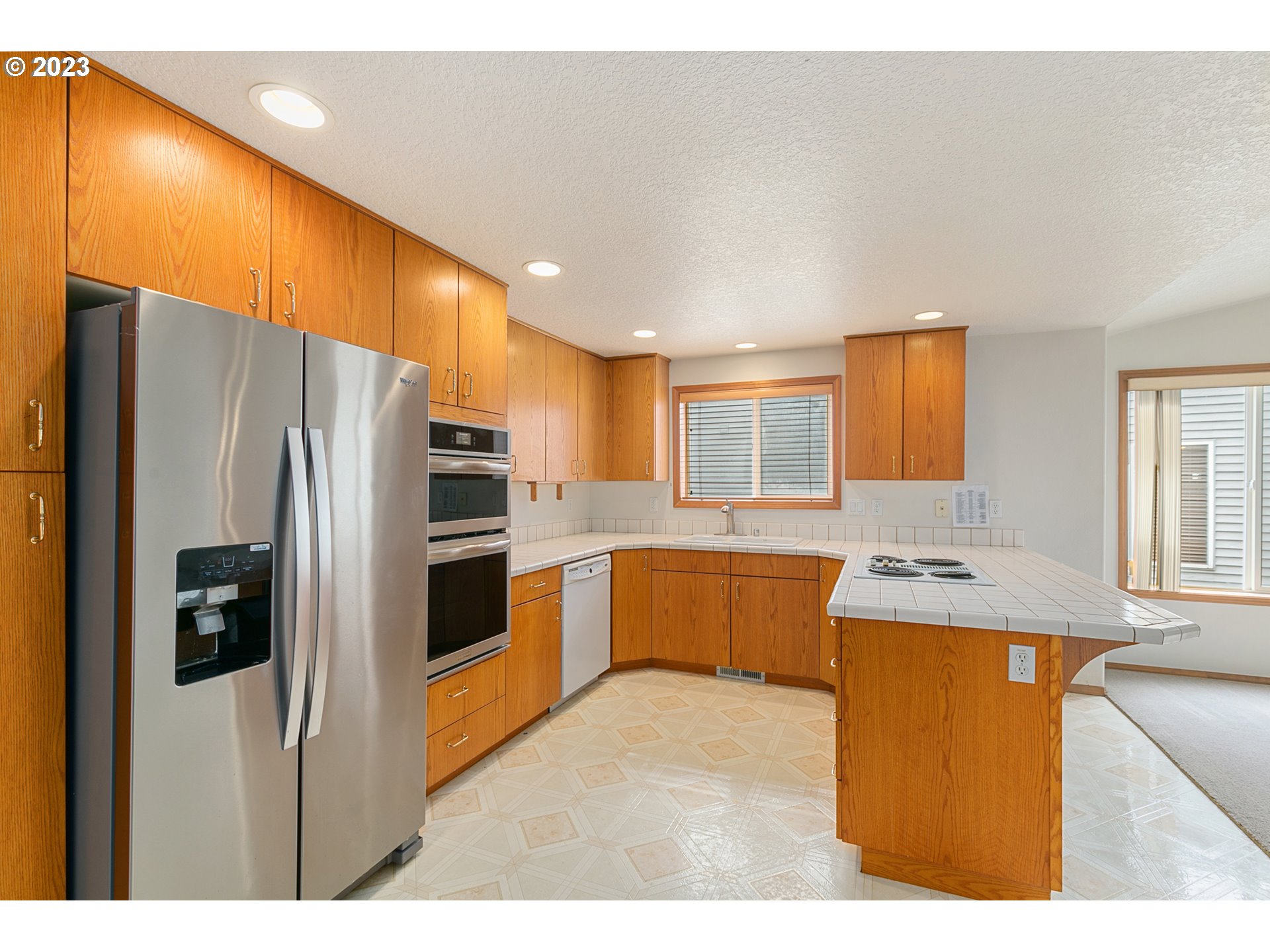 2217 Northeast 179th Street, Unit E10 Ridgefield, WA 98642 - Photo 8 of 23 a kitchen with stainless steel appliances kitchen island wooden cabinets a stove a sink and a refrigerator