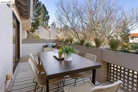 a view of a dining table and chairs in the roof deck of house