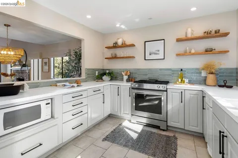 a kitchen with granite countertop white cabinets and appliances