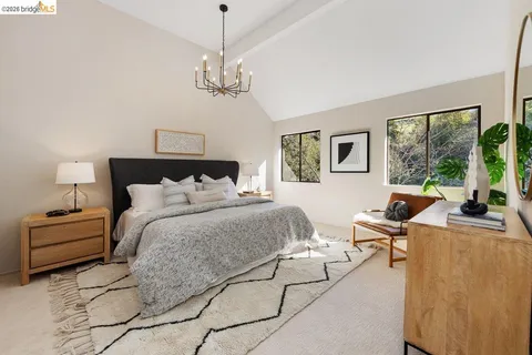 a spacious bedroom with a bed window and couch