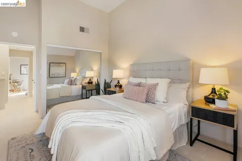 a bedroom with a bed and a lamp on dresser