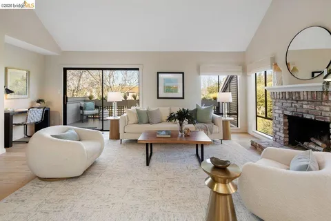 a living room with furniture a fireplace and a large window