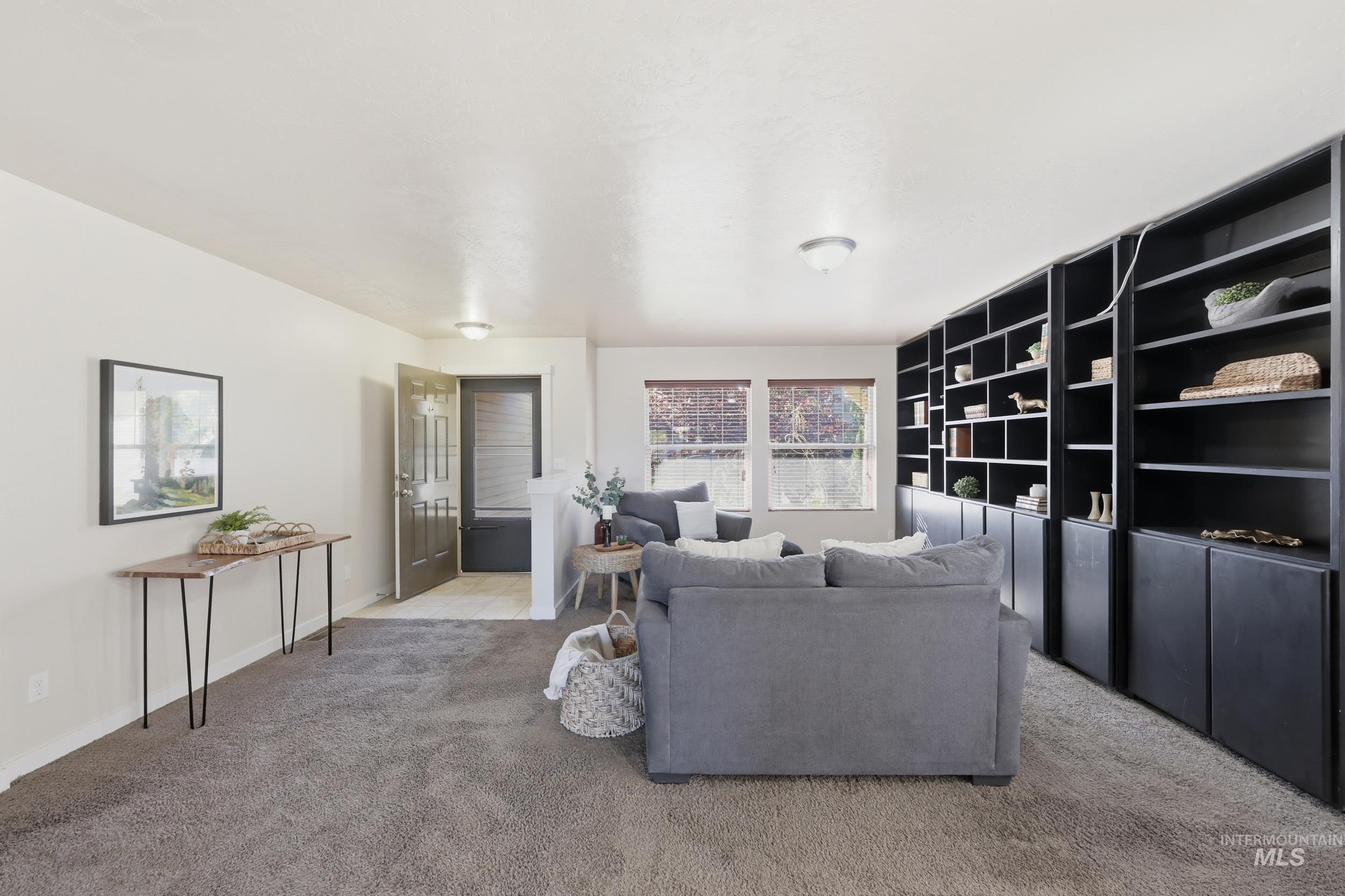 4855 South Chex Way Boise, ID 83709 - Photo 6 of 47 Living space featuring extensive built-in shelving with lower cabinetry, neutral carpeting, multiple windows with blinds, and recessed lighting