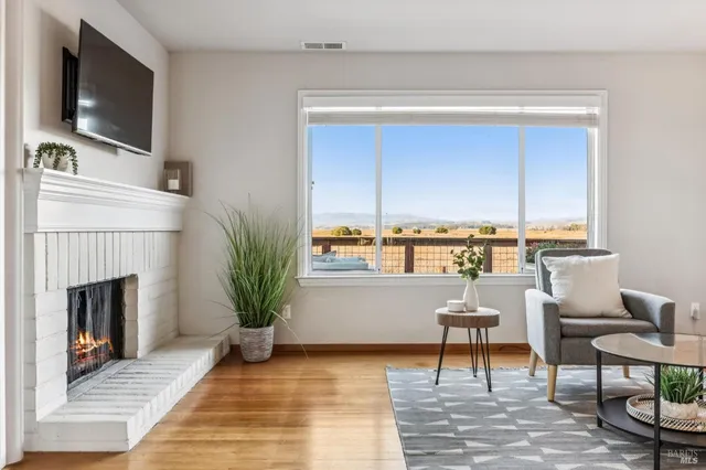 a view of a dining room with furniture clock and wooden floor