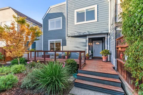 a view of a balcony with wooden floor and iron stairs