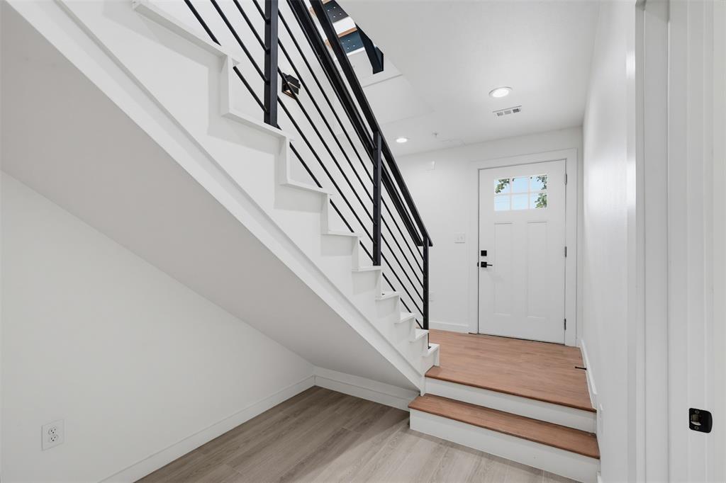 516 South O Connor Road Irving, TX 75060 - Photo 4 of 23 Contemporary staircase with black metal horizontal railings and light wood-finish treads