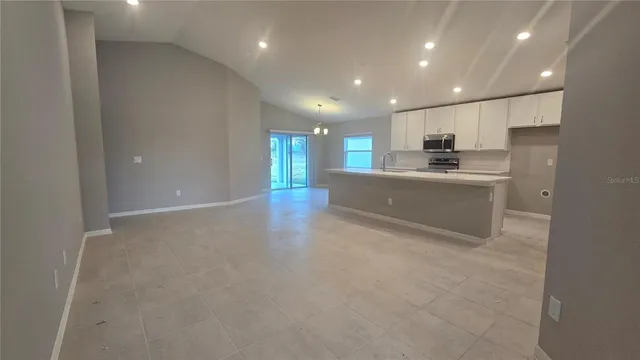 a view of kitchen with kitchen island white cabinets and stainless steel appliances