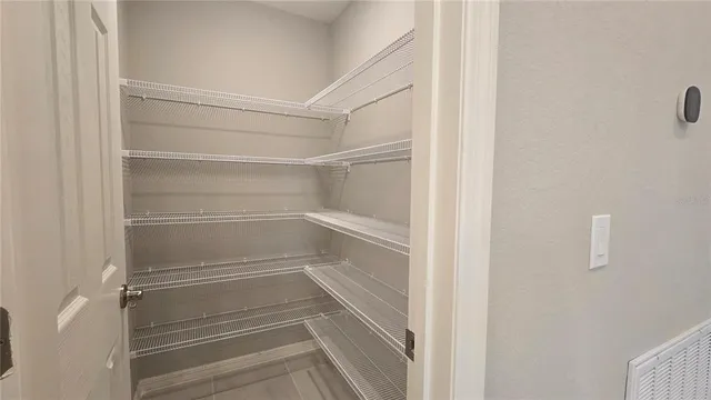 a view of walk in closet with empty racks