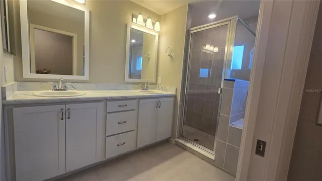 a bathroom with a granite countertop sink shower and a mirror