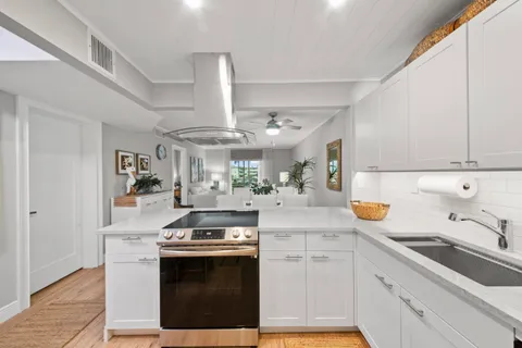 a kitchen with stainless steel appliances granite countertop a sink stove and cabinets