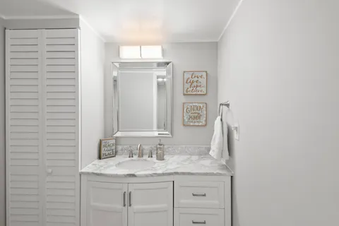 a bathroom with a granite countertop sink and a mirror
