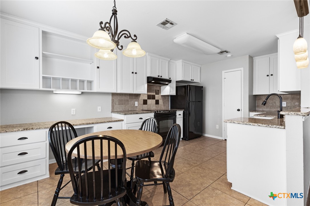 808 Silver Stone Drive Temple, TX 76502 - Photo 10 of 31 a kitchen with stainless steel appliances granite countertop a stove a refrigerator a sink a stove and white cabinets with wooden floor