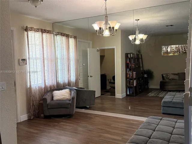 a living room with furniture and a chandelier
