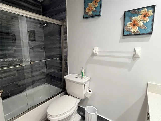 a white toilet sitting next to a bathroom sink