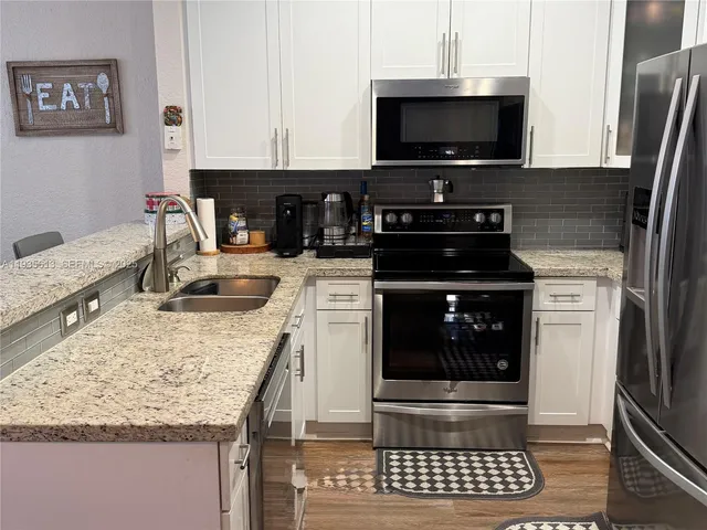 a kitchen with granite countertop a stove and a sink