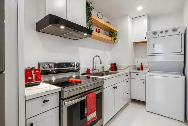a kitchen with a sink dishwasher and white cabinets