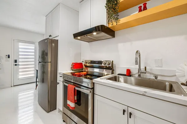 a kitchen with stainless steel appliances granite countertop a sink and a refrigerator