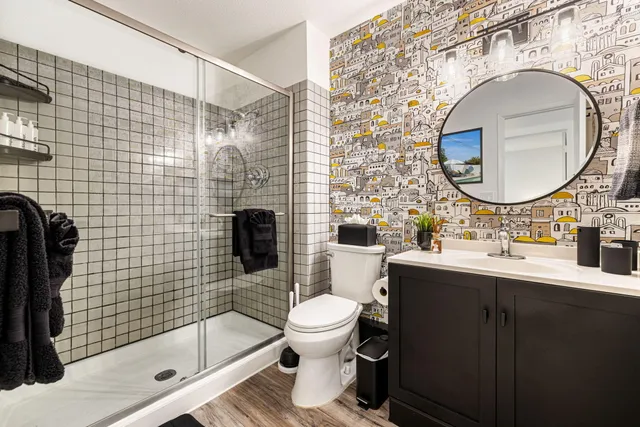 a bathroom with a sink mirror toilet and shower