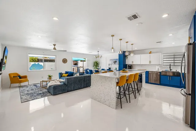 a living room with furniture and kitchen view