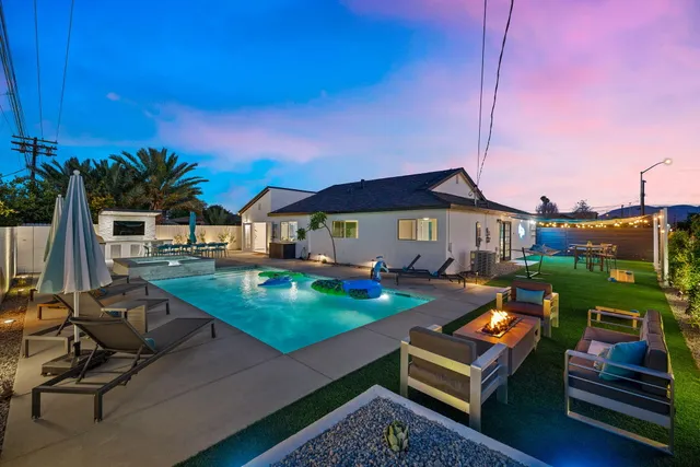 a view of a house with pool and chairs