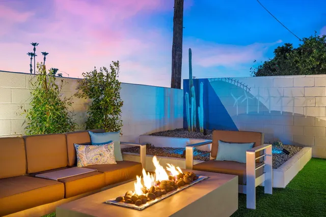 a view of a patio with couches table and chairs with wooden fence