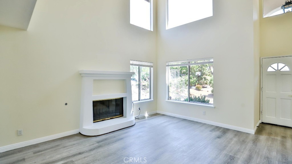 7855 Westpark Drive Riverside, CA 92506 - Photo 8 of 49 an empty room with wooden floor fireplace and windows