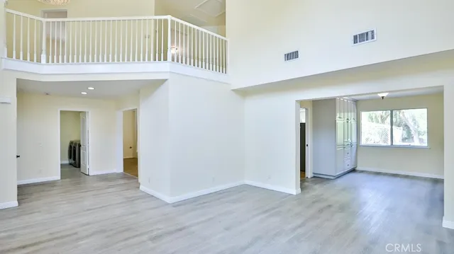 an empty room with wooden floor and a fireplace