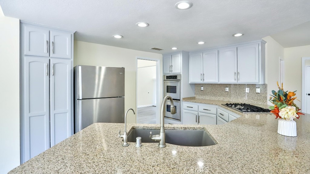 7855 Westpark Drive Riverside, CA 92506 - Photo 14 of 49 a kitchen with stainless steel appliances granite countertop a refrigerator a stove a sink and a granite counter tops