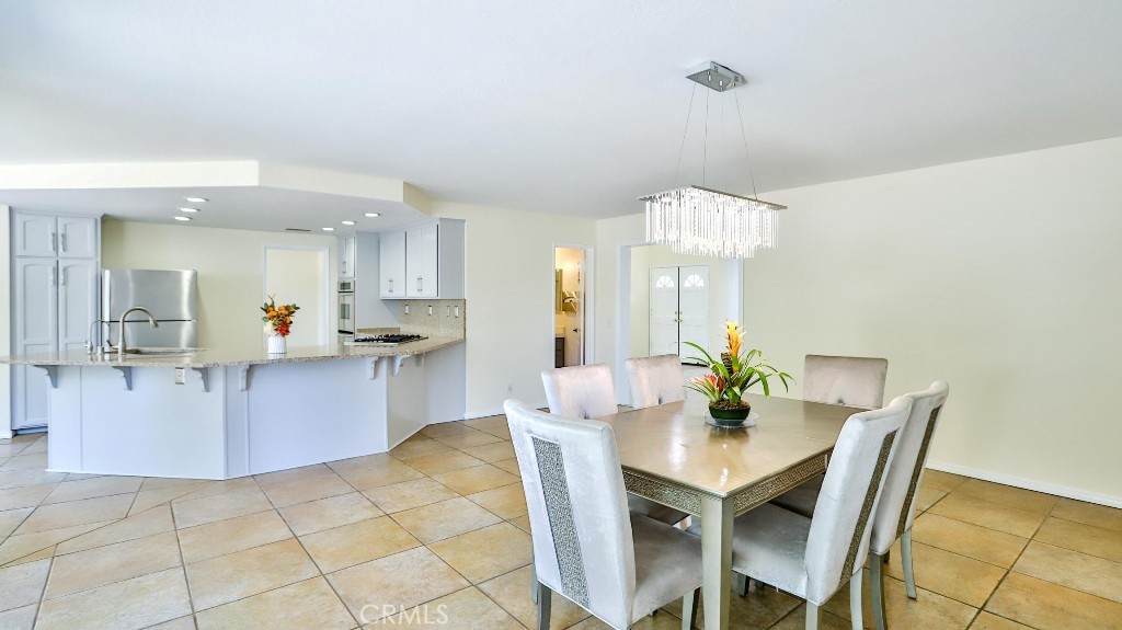 7855 Westpark Drive Riverside, CA 92506 - Photo 17 of 49 a kitchen with a dining table chairs and refrigerator