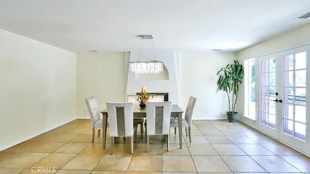 a kitchen with a dining table chairs and refrigerator