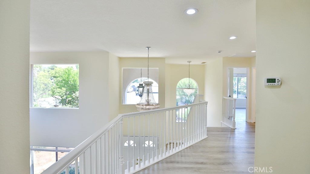 7855 Westpark Drive Riverside, CA 92506 - Photo 24 of 49 a view of a hallway with wooden floor and a chandelier