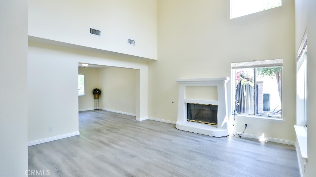 7855 Westpark Drive Riverside, CA 92506 - Photo 7 of 49 an empty room with wooden floor and a fireplace