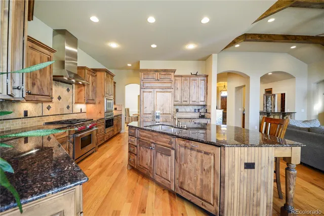 a large kitchen with stainless steel appliances granite countertop a stove and a sink