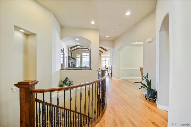 a view of a hallway with wooden floor and windows