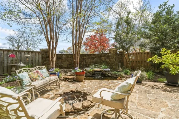 a view of backyard with seating space and trees