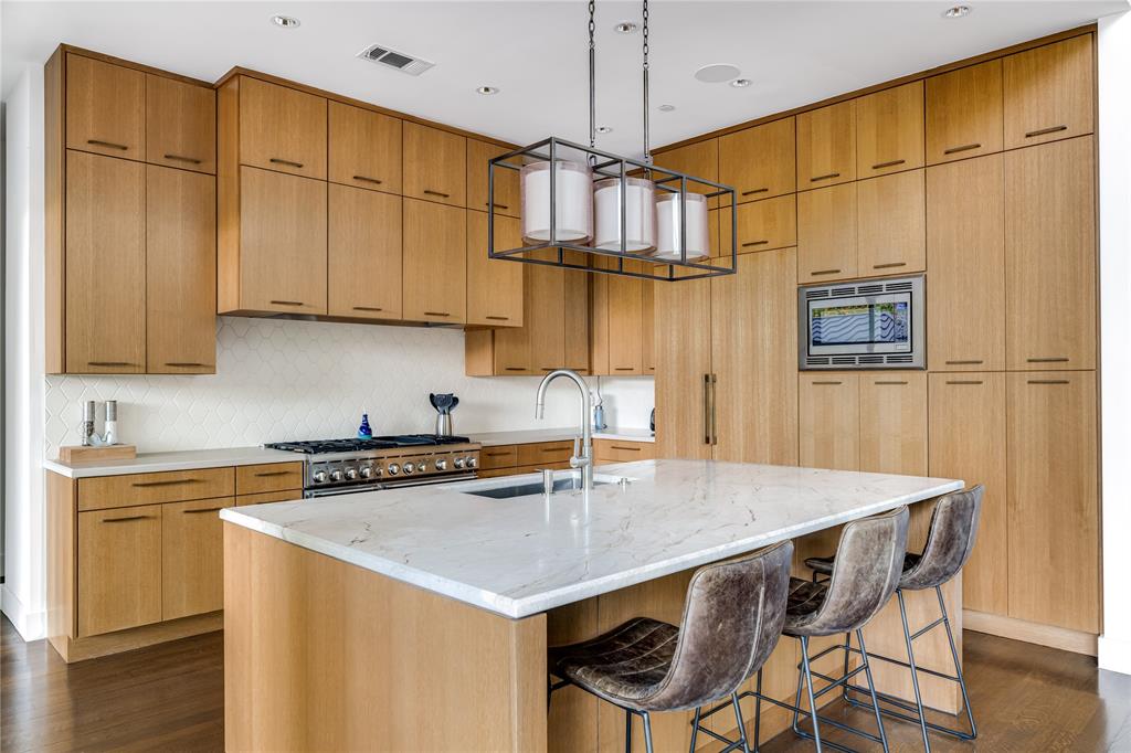 11460 Strait Lane Dallas, TX 75229 - Photo 15 of 39 a kitchen with stainless steel appliances granite countertop a stove a refrigerator a sink a dining table and chairs with wooden floor