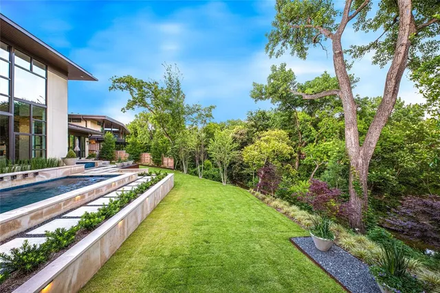a view of a patio with couches chairs potted plants and a palm tree