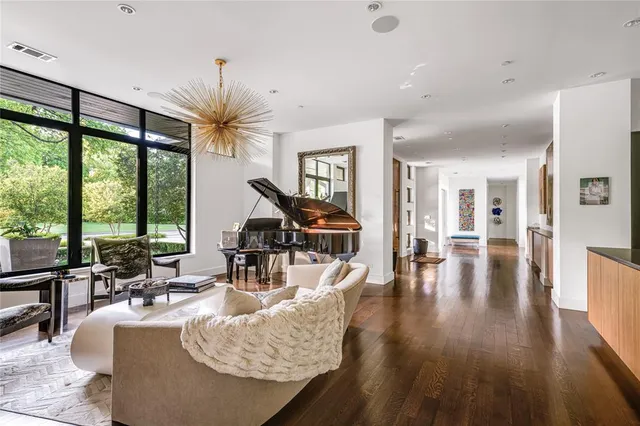 a living room with furniture large window and wooden floor