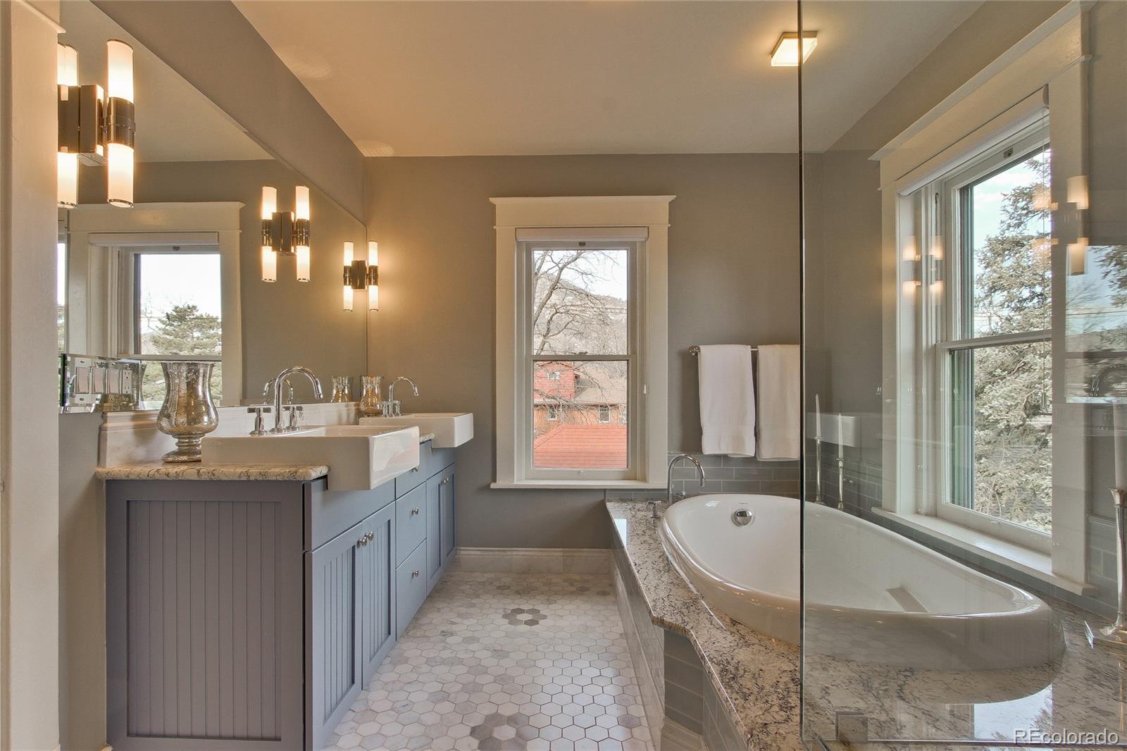 935 10th Street Boulder, CO 80302 - Photo 21 of 40 a bathroom with a granite countertop tub sink and mirror